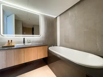 a bathroom with a tub and a sink and a mirror at Layan Green Residence by ShowProperty in Layan Beach