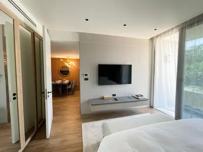 a bedroom with a bed and a tv on a wall at Layan Green Residence by ShowProperty in Layan Beach