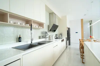 a kitchen with white cabinets and a sink at LuxPride 4BR Spacious Pool Villa for Group and Families in Ban Pak Lak