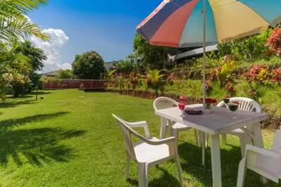 a table and chairs with an umbrella in a yard at Spacious 8BR Private Pool Villa in Chalong in Chalong
