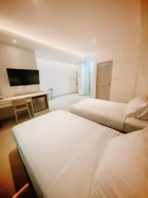 a hotel room with two beds and a television at The Sleepy Place in Patong Beach
