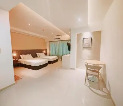 a hotel room with two beds and a table at The Sleepy Place in Patong Beach