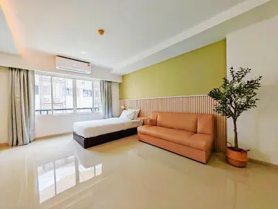 a bedroom with a bed and a couch and a chair at The Sleepy Place in Patong Beach