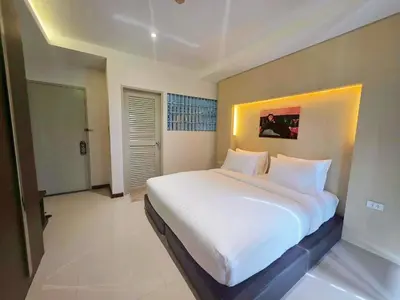 a bedroom with a large bed with white sheets at The Sleepy Place in Patong Beach