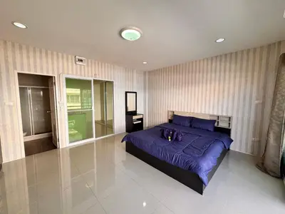 a bedroom with a large bed with purple sheets at Tropikathu Guest House in Kathu