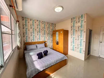 a bedroom with a bed with a dog laying on it at Tropikathu Guest House in Kathu