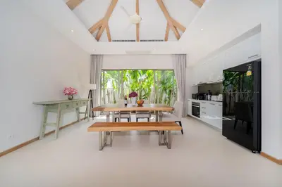 a dining room with a table and a kitchen at 3 Bedroom Villa with Private pool in Laguna Phuket