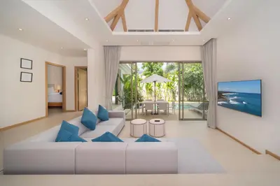 a living room with a white couch and blue pillows at 3 Bedroom Villa with Private pool in Laguna Phuket