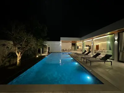 a swimming pool in a house at night at The Nature Villa Phuket in Rawai Beach