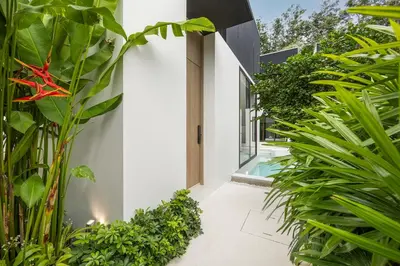 a house with white walls and green plants at Qabalah 2BR Villa Pool Rooftop Near Bangtao by TropicLook in Bang Tao Beach