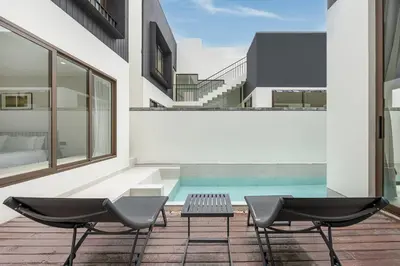 two chairs and a table on a balcony with a swimming pool at Qabalah 2BR Villa Pool Rooftop Near Bangtao by TropicLook in Bang Tao Beach