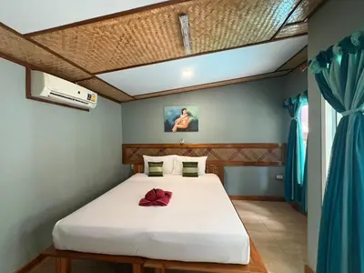 a bedroom with a white bed with a red bow on it at Phi Phi Ingphu Viewpoint Hotel in Phi Phi Don