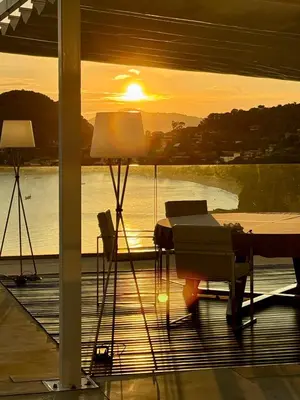 a sunset on a patio with a table and chairs at Cliff Top Residence in Phuket Town