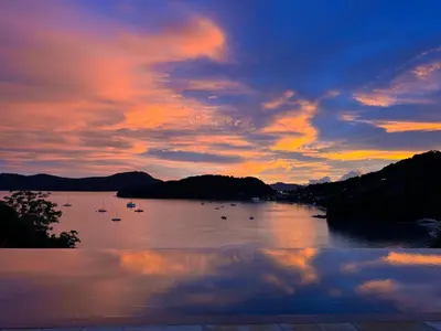 a sunset over a river with boats in it at Cliff Top Residence in Phuket Town