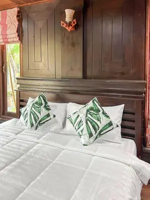 a large white bed with two pillows on it at Sun-San Thalane Resort in Ban Laem
