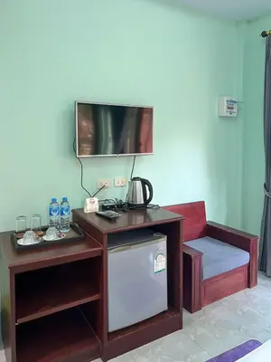 a room with a table and a tv on a wall at Sun-San Thalane Resort in Ban Laem