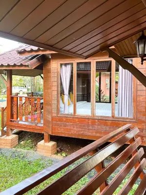 a wooden house with a porch with a window at Sun-San Thalane Resort in Ban Laem
