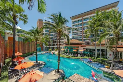 a pool at a hotel with palm trees and umbrellas at C202 Sun and Fun Kids Club 1BR 500m to Beach in Kata Beach