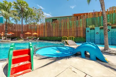 a swimming pool with a slide in a resort at C202 Sun and Fun Kids Club 1BR 500m to Beach in Kata Beach
