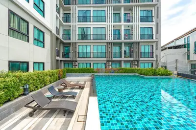 a swimming pool in front of a tall building at C203 Prime Area Near Beach, Dining & Shops in Bang Tao Beach