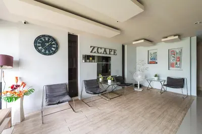 a room with chairs and a clock on the wall at C203 Prime Area Near Beach, Dining & Shops in Bang Tao Beach