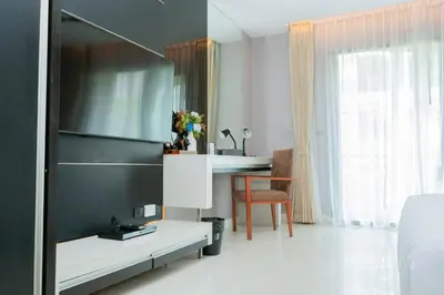 a bedroom with a bed and a desk and a table at Beachfront 1 BR Hotel Infinity Pool Patong Phuket in Patong Beach