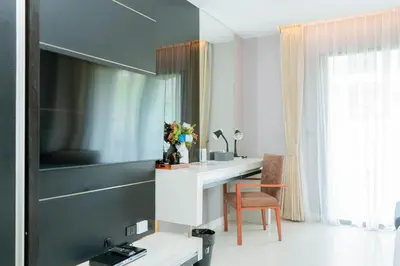 a bathroom with a sink and a desk with a mirror at Beachfront 1 BR Hotel Infinity Pool Patong Phuket in Patong Beach