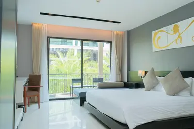 a hotel room with a bed and a balcony at Beachfront 1 BR Hotel Infinity Pool Patong Phuket in Patong Beach
