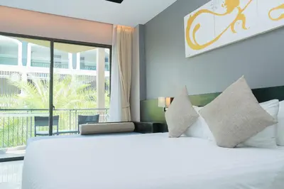 a bedroom with a large bed and a large window at Beachfront 1 BR Hotel Infinity Pool Patong Phuket in Patong Beach