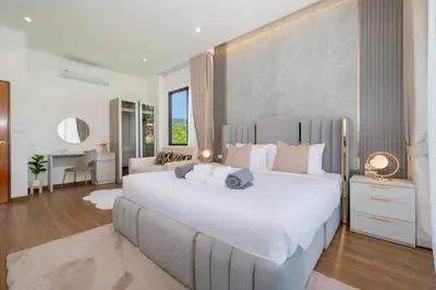 a bedroom with a large white bed and a desk at Kamala Sunshine Villa - Goldena Twin in Kamala Beach