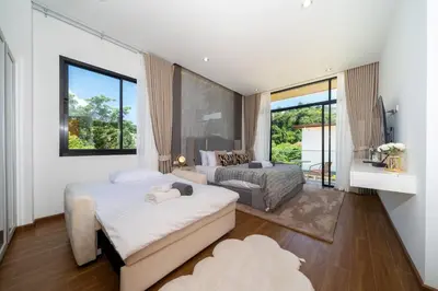 a bedroom with two beds and a couch at Kamala Sunshine Villa - Goldena Twin in Kamala Beach
