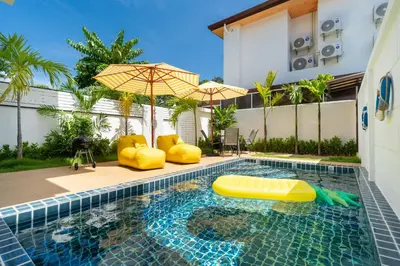 a swimming pool with an umbrella and an inflatable at Kamala Sunshine Villa - Goldena Twin in Kamala Beach