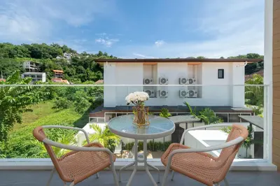 a patio with a table and chairs on a balcony at Kamala Sunshine Villa - Goldena Twin in Kamala Beach
