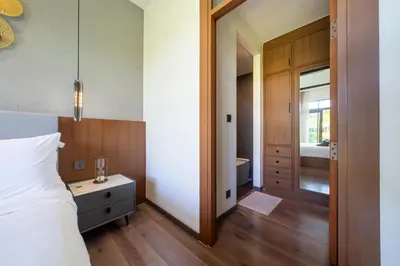 a bedroom with a bed and a door leading to a bathroom at Ocean Palms Private Pool Villas in Ban Thalat Choeng Thale