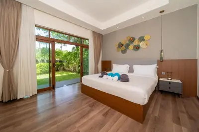 a bedroom with a bed with a stuffed animal on it at Ocean Palms Private Pool Villas in Ban Thalat Choeng Thale