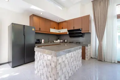 a kitchen with a large island in the middle at Ocean Palms Private Pool Villas in Ban Thalat Choeng Thale