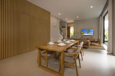 a dining room with a long wooden table and chairs at Chalong Bay View 3BR Pool Villa Long One B10 in Chalong