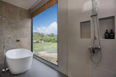 a bathroom with a bath tub and a window at Chalong Bay View 3BR Pool Villa Long One B10 in Chalong