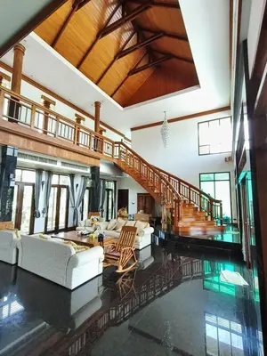 a living room with white couches and a staircase at Phu-Pha Thara Villa Phuket in Ban Saiyuan (1)