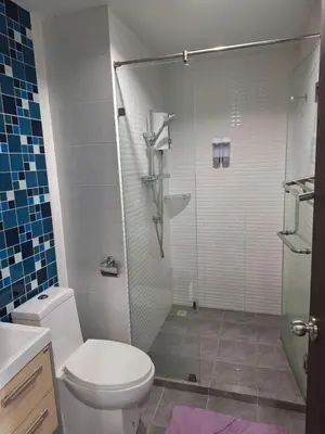 a bathroom with a toilet and a glass shower at The Sea Condo Ao Nang Apartment Relax with Sea View in Ban Khlong Haeng
