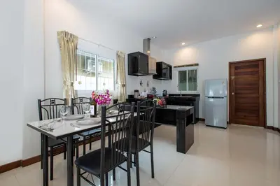 a kitchen and dining room with a table and chairs at Family 2BR Villa Lancelot 3 with Jacuzzi Pool, just 10 min drive NaiHarn and Rawai in Rawai Beach
