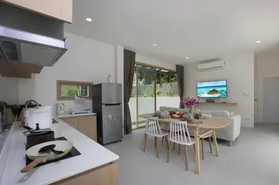 a kitchen and living room with a table and chairs at Your Tropical Island Home - New & Modern 2BR Pool Villa Seamate in Chalong