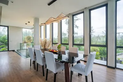 a dining room with a table and chairs and windows at Luxury Beachfront Sea-View Retreat & Pool in Natai in Ban Na Tai