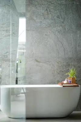 a white bath tub in a bathroom with a stone wall at Luxury Beachfront Sea-View Retreat & Pool in Natai in Ban Na Tai