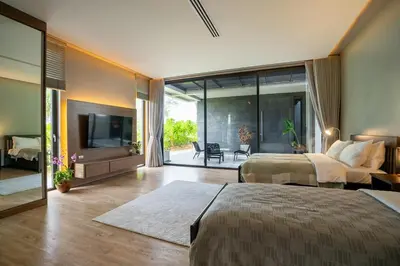 a large bedroom with two beds and a television at Luxury Beachfront Sea-View Retreat & Pool in Natai in Ban Na Tai