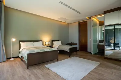 a hotel room with a bed and a couch and a bedroom at Luxury Beachfront Sea-View Retreat & Pool in Natai in Ban Na Tai