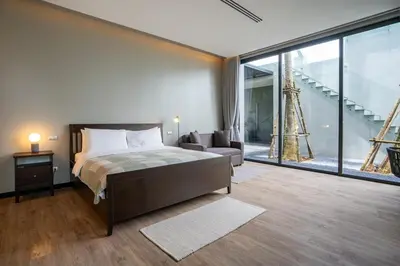 a bedroom with a bed and a couch and a large window at Luxury Beachfront Sea-View Retreat & Pool in Natai in Ban Na Tai