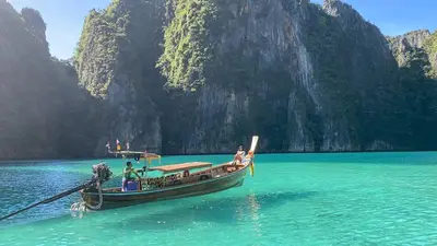 a boat in the water with people on it at Phi Phi Cliff Beach Resort in Phi Phi Don