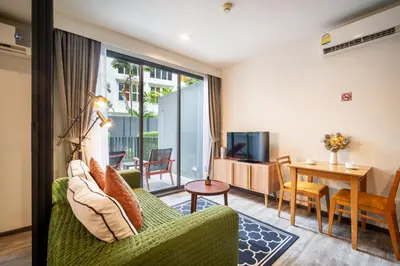 a living room with a green couch and a table at \u7cbe\u9009\u623f\u6e906\u53f7\u82ad\u4e1c\u6d77\u6ee9\u7cbe\u88c5\u516c\u5bd35\u5206\u949f\u5230\u6d77\u6ee910\u5206\u949f\u5230\u6d77\u6ee9Bangla\u9152\u5427\u8857Jungceylon\u5546\u573a in Patong Beach