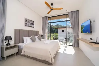 a bedroom with a bed and a ceiling fan at Villa Chandlers - Goldena Twin in Kamala Beach